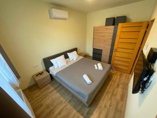 a small bedroom with a bed with two towels on it at Park Central Tapolca - Apartments in Miskolctapolca