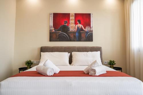 a bedroom with a large bed with a painting on the wall at LP Luxury Suite - Old Town Xanthi in Xanthi