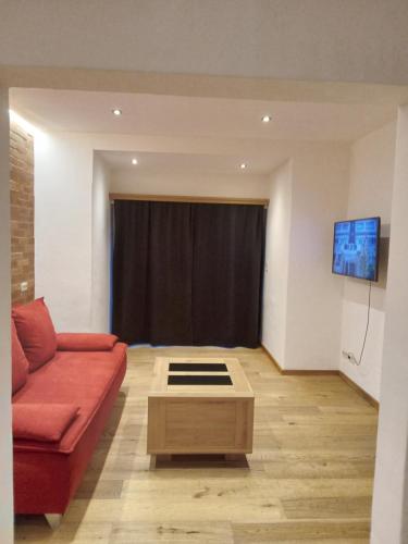 salon z czerwoną kanapą i telewizorem w obiekcie MIKAS HAUS w mieście Bad Aussee