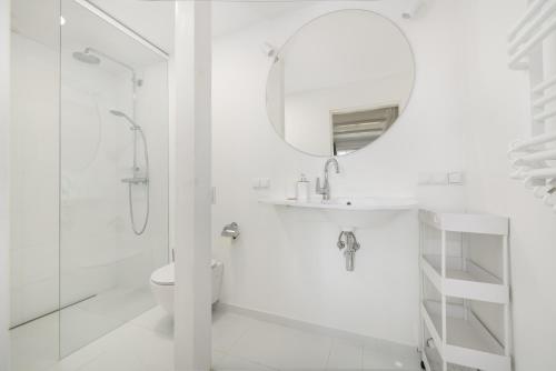 a white bathroom with a sink and a mirror at Studio Vintage na Kamiennej Górze in Gdynia