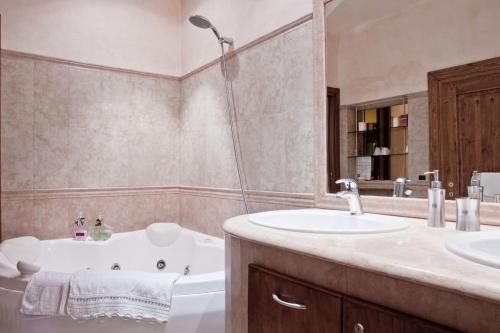 a bathroom with a tub and a sink and a bath tub at Locanda Modigliani in Ferrara