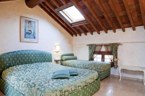 a bedroom with a bed and a couch and a window at Locanda Modigliani in Ferrara