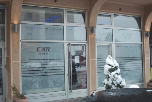 a store front with a snow covered tree in front of it at Car Royal Apartments and Rooms in Novi Sad