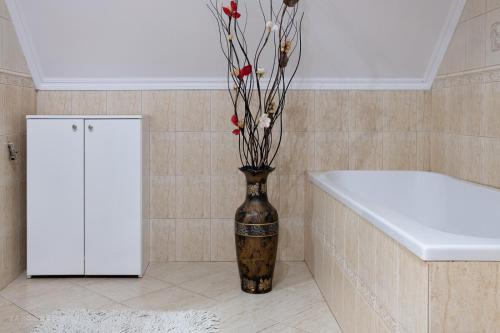 a vase with flowers in the corner of a bathroom at Kaszubski Dworek in Sznurki