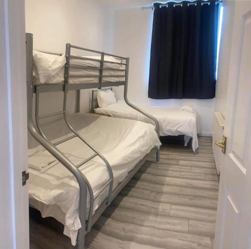 Ce dortoir comprend 2 lits superposés et une fenêtre. dans l'établissement Entire Two Double Bedrooms Flat N4, à Great Yarmouth