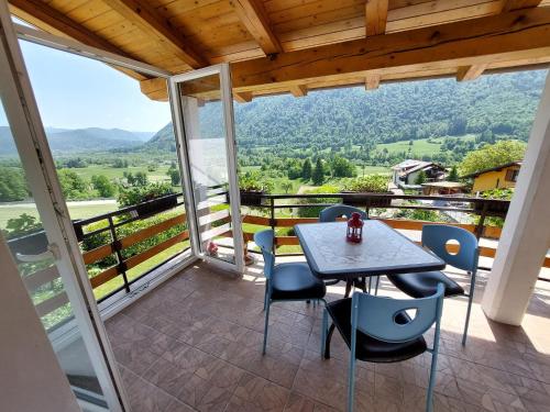 a table and chairs on a balcony with a view at Apartments Denis in Tolmin