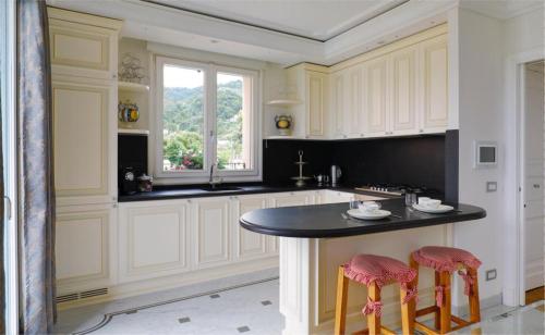 a kitchen with white cabinets and a black island with stools at SUNSET with view in Seborga in Seborga