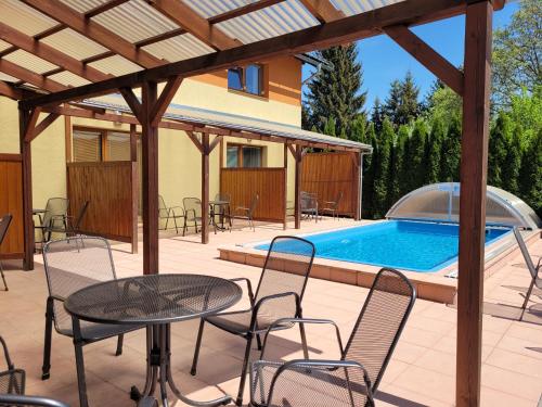 a patio with a table and chairs and a swimming pool at Velký apartmán Sophia (s infrasaunou) č. 1 in Velké Losiny