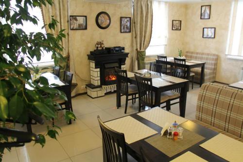 a restaurant with tables and chairs and a fireplace at Ost-roff Hotel in Izhevsk