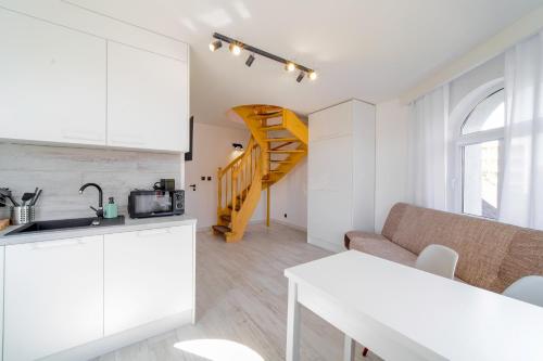 a kitchen and living room with a couch and a table at Dobre smaki at Wczasowa8 sea resort in Sarbinowo