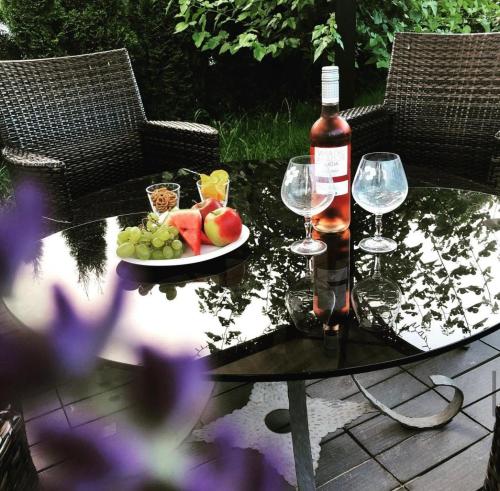 stół z talerzem owoców i butelką wina w obiekcie Gästehaus Isler w mieście Leutkirch im Allgäu