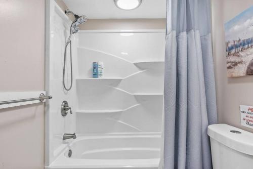 a shower in a bathroom with a shower curtain at Radiant Beach Block Condo Parking Patio in Brigantine