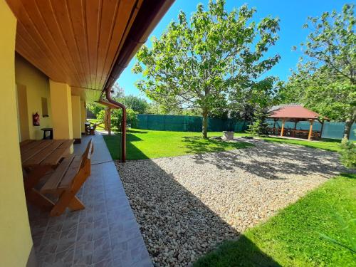 a patio with a bench and a yard at Potyka Apartman in Tiszafüred