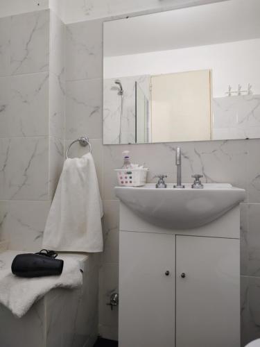 a white bathroom with a sink and a mirror at Porteño 7 Hospital Italiano in Buenos Aires
