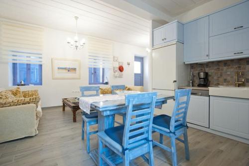 a kitchen and dining room with blue chairs and a table at LocriHOUSE-Stylish comfortable home in Galaxidi in Galaxidhion
