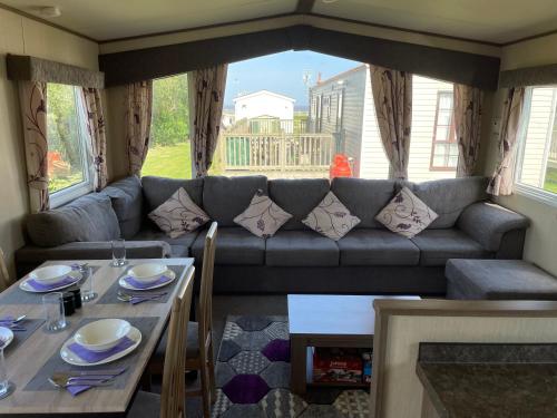 een woonkamer met een bank en een tafel bij PK Holiday Home in Great Yarmouth