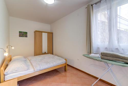 a small bedroom with a bed and a window at Dora Apartment-Adults Only in Senj