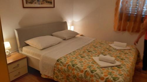 1 dormitorio con 1 cama con 2 toallas en Apartmani MW , Zuti apartman, en Baška