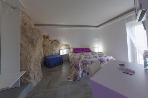 a bedroom with a bed and a stone wall at Terrazza Santa Barbara in Matera