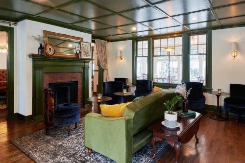 a living room with a green couch and a fireplace at The Whitlock by The Lenox Collection in Lenox