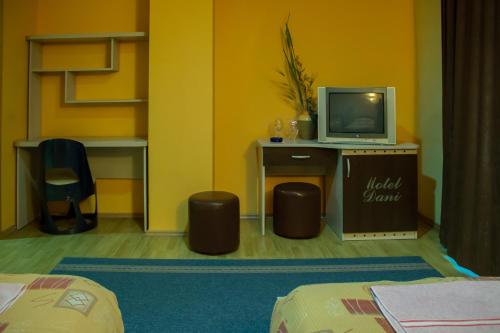 a room with a tv on a desk with two stools at Motel Dani in Nova Bila