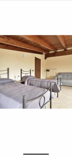 fila de camas en una habitación con techos de madera en VENTO DI FANUSA en Fanusa