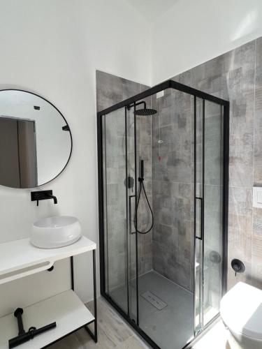 uma casa de banho com uma cabina de duche em vidro e um lavatório. em Casa Azzurra 1 em Santa Teresa Gallura