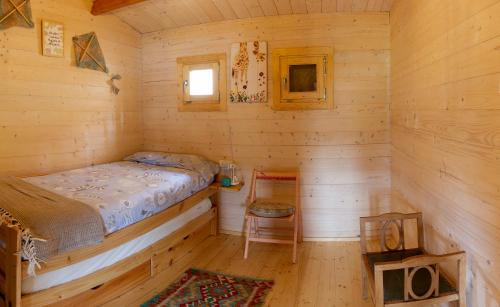 una camera con un letto in una baita di tronchi di Cabaña IkiZen a Barbadillo del Pez