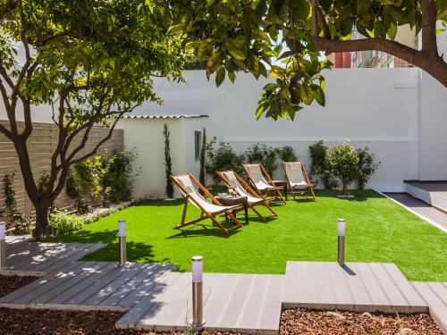a lawn with lounge chairs on it at Vila Garden Guesthouse in Lisbon