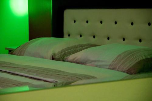 a bedroom with a bed with a green light at Motel Dani in Nova Bila