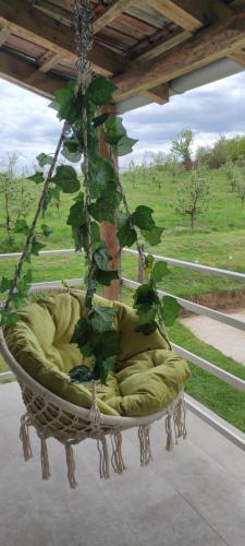 a hanging chair with green cushions on a porch at Vikend house in Ljig