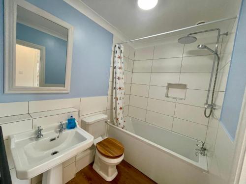Un baño con lavabo, inodoro y ducha. en Cosy Victorian Apartment - Central York, en York