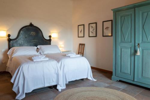 a bedroom with two beds with white sheets at Tenuta Il Cicalino in Massa Marittima