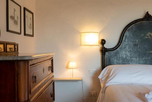 a bedroom with a bed and a lamp on a dresser at Tenuta Il Cicalino in Massa Marittima