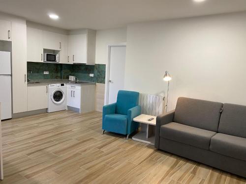 ein Wohnzimmer mit einem Sofa und einer Küche in der Unterkunft Apartamentos Torreones de Cartes in Cartes