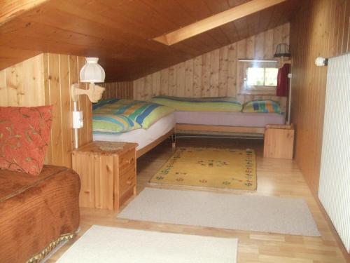 um quarto com 2 camas num chalé de madeira em Apartment Nadeschda em Adelboden