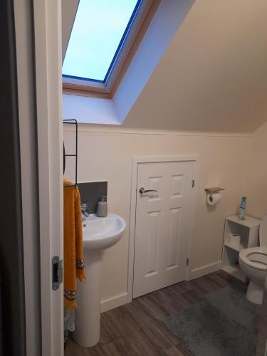 a bathroom with a sink and a skylight at Spacious Ensuite King Room Private Neighbourhood Free Parking Space in Oldham