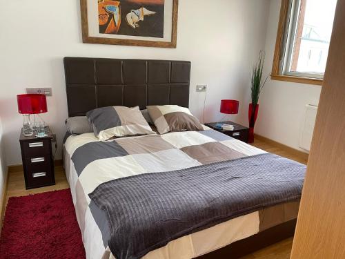 a bedroom with a large bed with two lamps at Malpica Vistas in Malpica