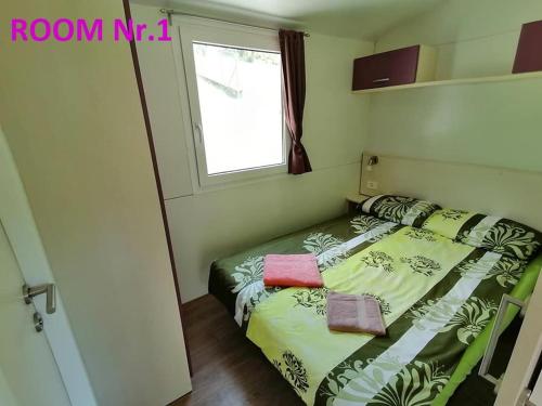 a small bedroom with a bed in a room at MOBILE HOUSE KD in Tolmin