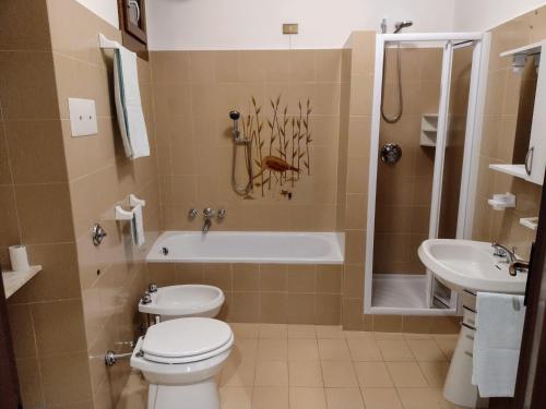a bathroom with a toilet and a tub and a sink at Appartamento Teoperga in Sotto il Monte