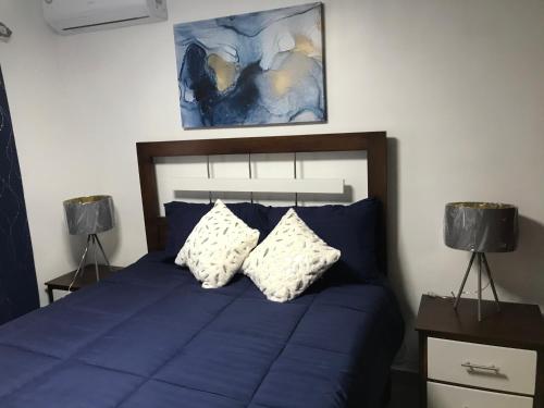 a bedroom with a blue bed with two lamps at Residencial Santa Rosa Apto 8 Section C in Moca