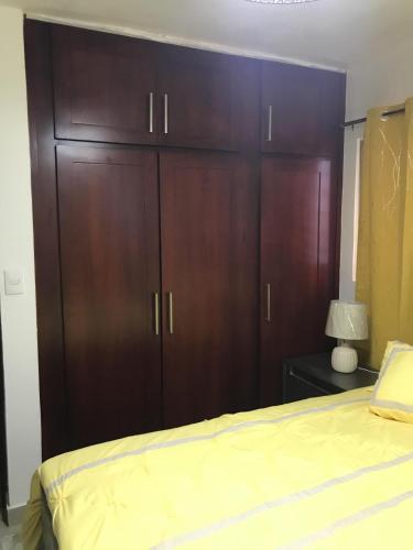 a bedroom with a large wooden cabinet next to a bed at Residencial Santa Rosa Apto 8 Section C in Moca