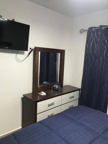 a bedroom with a bed and a dresser with a mirror at Residencial Santa Rosa Apto 8 Section C in Moca