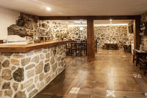 un restaurante con una pared de piedra y un bar en Casa Rural La Fontanita, en El Real de San Vicente