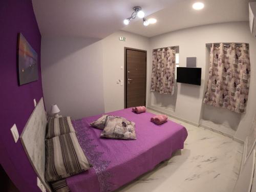 a bedroom with a purple bed and purple sheets at MEMORIA in Corfu