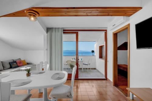 ein Wohnzimmer mit einem weißen Tisch und Meerblick in der Unterkunft Apartment Amfora in Podgora