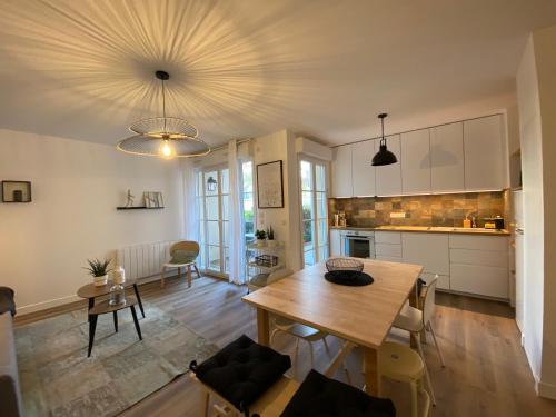 Il comprend une cuisine et une salle à manger avec une table en bois. dans l'établissement La Serrisienne 5 - Val d'Europe - Disneyland Paris - 6 à 8 Personnes, à Serris