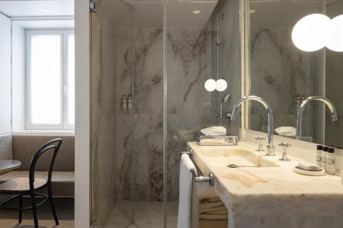 a bathroom with a sink and a shower with a mirror at Lisboa Pessoa Hotel in Lisbon
