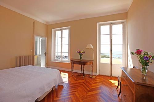 - une chambre avec un lit et une table fleurie dans l'établissement PALMERAIE - Magnifique appartement d'époque avec Vue Mer 4 personnes avec terrasse Le Port Nice, à Nice