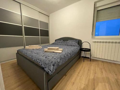 - une chambre avec un lit, du parquet et une fenêtre dans l'établissement New Sky Terrace, à Belgrade